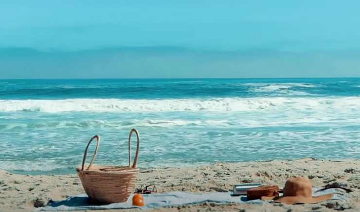 una spiaggia con un asciugamano e una borsa