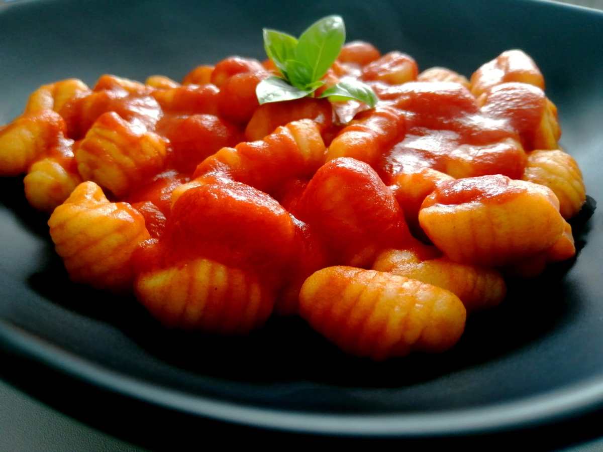 gnocchi al sugo su un piatto nero