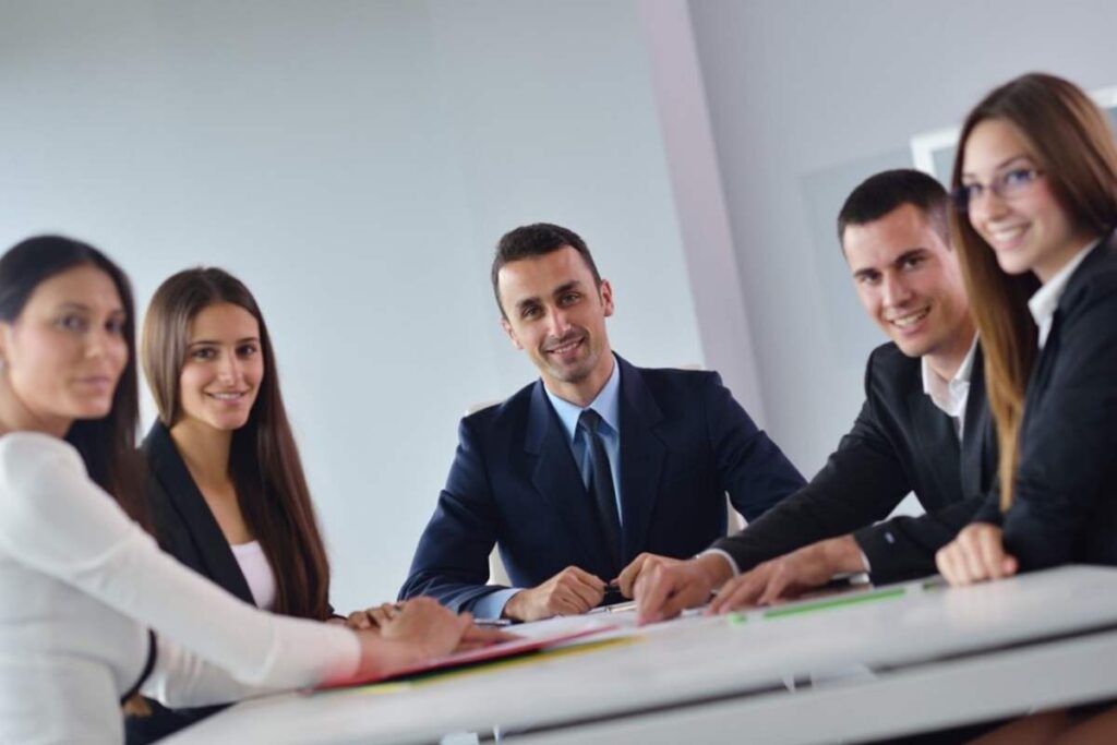 persone vestite da lavoro intorno ad un tavolo che sorridono