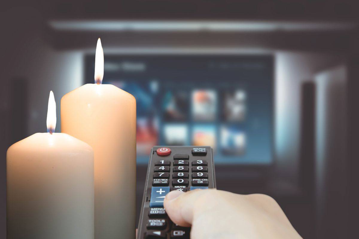 una tv con telecomando e due candele