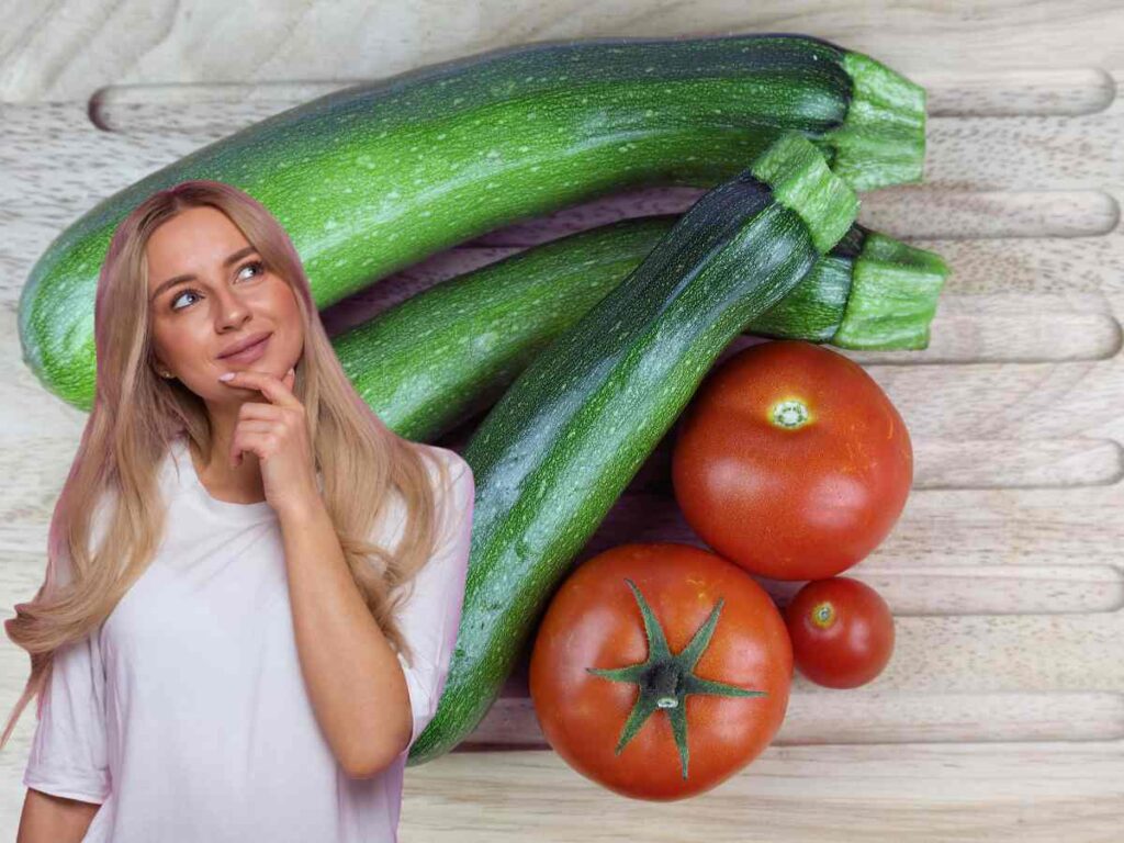 zucchine e pomodori su ripiano di legno e una donna