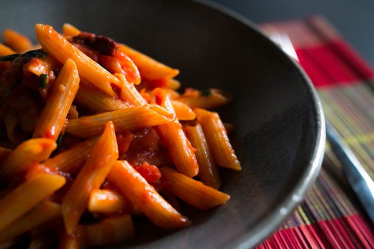 penne al ragù dentro un piatto nero