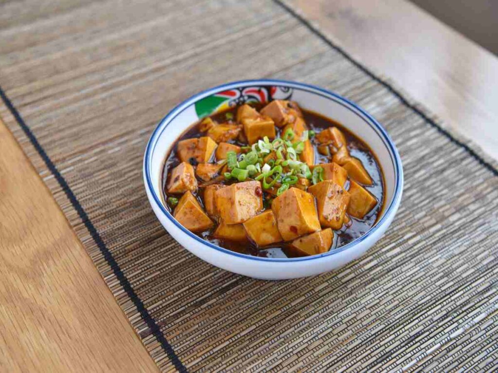 ciotola con tofu tagliato a cubetti e salsa di pomodoro